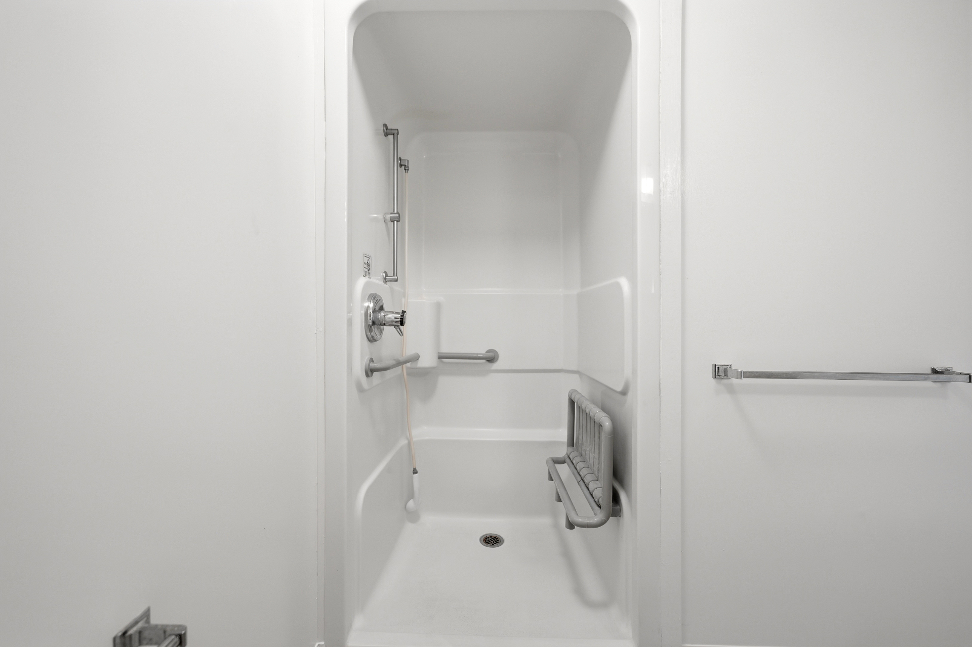 Accessible shower stall with grab bars and seat
